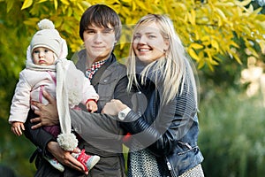 Photo of happy family with daughter outdoors in autumn