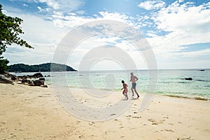 Photo of happy father and son spending time together, running on summer tropical beach. family fun. Tourism. Vacation