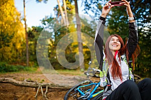 Photo of happy girl photographing herself in autumn forest