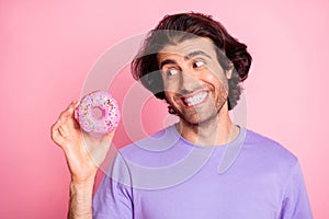 Photo of happy hungry young man hold look doughnut tasty unhealthy pastry isolated on shine pink color background