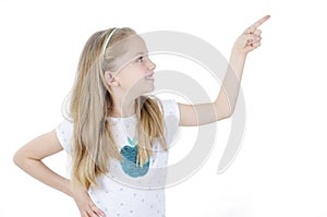 Photo of happy little girl standing. Looking side showing copyspace pointing.