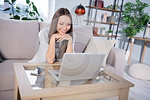 Photo of happy positive good mood beautiful woman sit sofa enjoying watching film in laptop having break at home