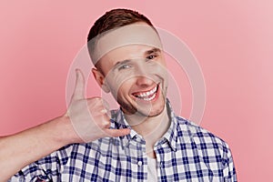 Photo of happy positive smile man make call me gesture phone speak tell isolated on pink color background