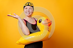 Photo of happy woman in bathing suit with life preserver on empty orange background