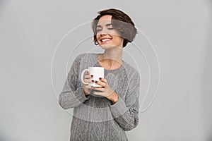 Happy young lady drinking tea.