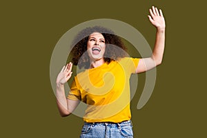 Photo of happy young woman curly hair chevelure raised hands up on discotheque love techno music isolated over khaki