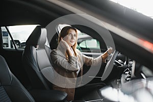 Photo of happy young woman sitting inside her new car. Concept for car rental.
