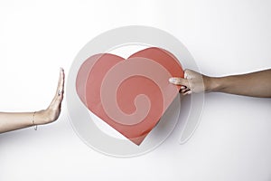 A photo of a heart being denied by someone,  on white background. Unrequited love concept