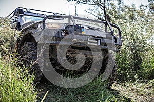 Photo of heavy off-road racing car overcomes hard pit.