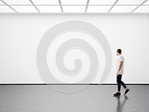 Photo of hipster in modern gallery looking at the empty canvas. Blank mockup, motion blur