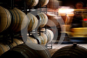 Photo of historical wine barrels in winery cellar with forklift photo