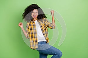 Photo of hooray curly hairdo millennial lady hands fists wear yellow shirt jeans isolated on green color background
