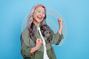 Photo of hooray elder white hairdo lady yell wear green shirt isolated on blue color background