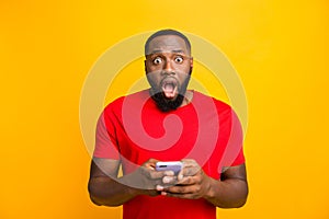 Photo of horrified scared surprised negative man who saw something terrible while browsing through his phone while