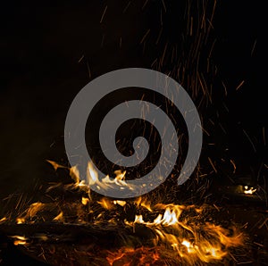 Photo of hot sparking live-coals burning, spark of bonfire