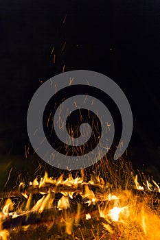 Photo of hot sparking live-coals burning, spark of bonfire