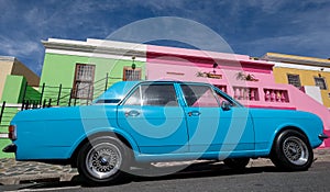 Photo of houses in the Malay Quarter, Bo-Kaap, Cape Town, South Africa with vintage Ford Cortina car outside on street.