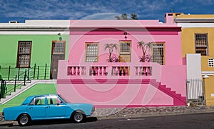 Photo of houses in the Malay Quarter, Bo-Kaap, Cape Town, South Africa with vintage Ford Cortina car outside on street.