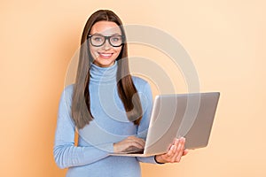 Photo of hr brunette millennial lady type laptop wear eyewear blue pullover isolated on beige color background