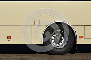 Photo of the hull of a large and long yellow bus with free space for advertising. Close-up side view of a passenger vehicle for t