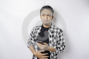 Photo of a hungry excited young man holding his phone and wondering what to order yummy food isolated on white color background