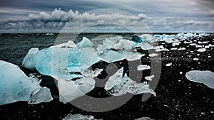 Photo of icebergs cast away on dark beach