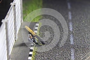 Photo Illustration, Hopeless Sad Old Man Mini Figure Toy Sitting at sidewalk, beside burned match stick represented as spirit