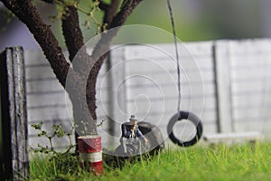 Photo Illustration, Sitting Hopeless Sad Old Man Mini Figure Toy under the tree