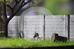 Photo Illustration, Sitting Hopeless Sad Old Man Mini Figure Toy under the tree