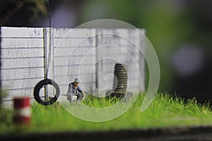 Photo Illustration, Sitting Hopeless Sad Old Man Mini Figure Toy under the tree