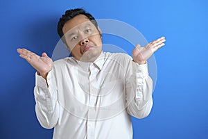 Photo image of Asian businessman with shrug shoulder up gesture