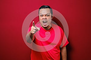 Photo image of funny Asian man showing cynical unhappy angry facial expression pointing forward giving warn