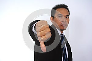 Photo image of a handsome attractive young Asian businessman with thumb down hand