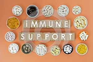 Photo on immune support theme. wooden cubes with the inscription `immune support` and biologically active supplements