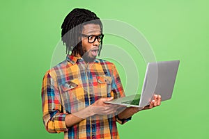 Photo of impressed funky dark skin man wear plaid shirt spectacles looking modern device  green color background