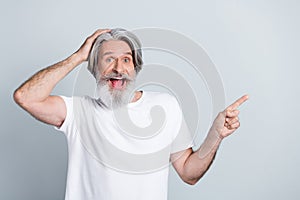 Photo of impressed funky man pensioner dressed white t-shirt arm head pointing finger empty space isolated grey color photo
