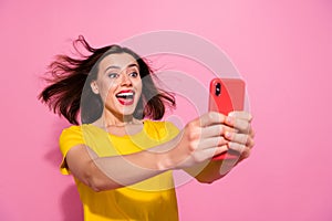 Photo of impressed funky young woman wear yellow outfit air blowing writing modern device smiling isolated pink color