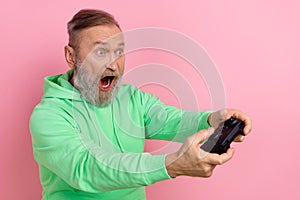 Photo of impressed funny guy dressed green hoodie loosing playstation game empty space isolated pink color background