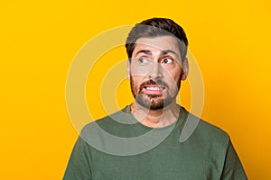 Photo of impressed guilty man wear khaki t-shirt looking empty space isolated yellow color background