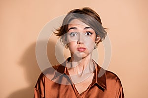 Photo of impressed speechless woman wear silky blouse bloated cheeks  beige color background