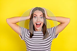 Photo of impressed young brunette lady hands head wear striped t-shirt isolated on yellow background