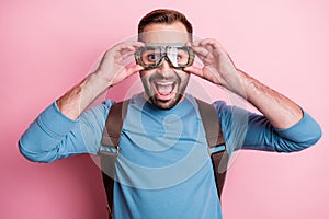 Photo of impressed young man dressed blue sweater arms eyewear rucksack ready jump parachute isolated pink color