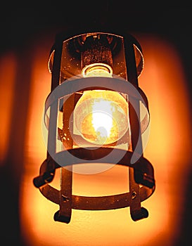 Photo of an incandescent lamp light on in rustic support. photo