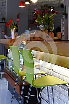 A photo of an interior of a cozy modern urban cafe with low warm light and noone inside photo