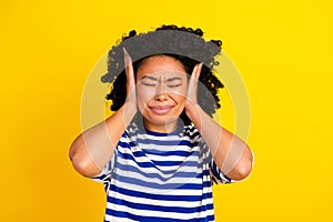 Photo of irritated girl closed eyes wear trendy clothes avoid loud noise sound isolated on yellow color background