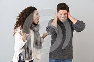 Photo of irritated man and woman screaming while fighting together, isolated over gray background