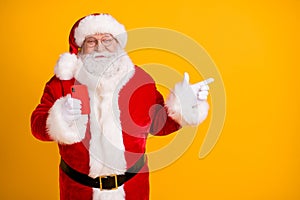 Photo of jolly holly fat santa claus use smartphone point finger copyspace follow x-mas christmas eve adverts discount
