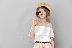 Photo of joyful brunette woman 20s wearing straw hat and summer