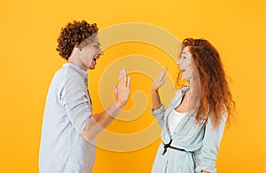 Photo of joyful couple man and woman standing face to face and g