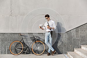 Photo of joyful man 30s wearing sunglasses, drinking takeaway co